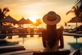 Young woman in swimsuit and straw hat sitting at the edge of swimming pool.Generative AI Royalty Free Stock Photo