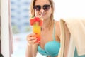 Young woman in swimsuit and sunglasses drinking cocktail on vacation closeup Royalty Free Stock Photo