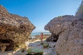 Young woman in swimsuit between two rocks on the beach Royalty Free Stock Photo