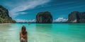 Young woman in swimsuit walking on the beach in Thailand.