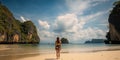 Young woman in swimsuit walking on the beach in Thailand.