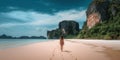 Young woman in swimsuit walking on the beach in Thailand.