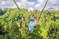 Young woman swinging in the jungle rainforest of Bali island, Indonesia. Swing in the tropics. Swings - trend of Bali