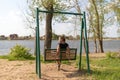 Young woman swinging on a swing. Girl sitting on a swing