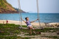 Young woman swinging on a swing on a tropical beach Royalty Free Stock Photo