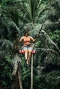 BALI, INDONESIA - MAY 16, 2018: Young woman swings in the jungle of Bali island. Rainforest of Indonesia. Travel concept