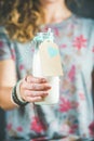 Young woman in t-shirt holding bottle of dairy-free almond milk Royalty Free Stock Photo