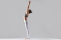 Young woman in Tadasana pose, grey studio background