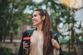 Young woman with take away coffee in hand in casual clothes near river water