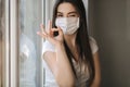 Young woman take off protective mask. Female in white t-shirt and white medical mask. End of quarantine. Coronavirus Royalty Free Stock Photo