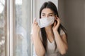 Young woman take off protective mask. Female in white t-shirt and white medical mask. End of quarantine. Coronavirus Royalty Free Stock Photo