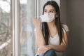 Young Woman take off protective mask and use smartphone. End of quarantine. Coronavirus theme Royalty Free Stock Photo