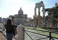 Young woman take photo with smartphone to the Imperial forums Fori Imperiali in Rome.