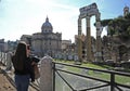 Young woman take photo with smartphone to the Imperial forums Fori Imperiali in Rome