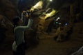 Woman take photo of stone cave. tourist take picture of cavern w