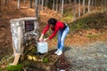 Young woman take a water on drinking fountain in a forest Royalty Free Stock Photo