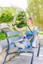 Young woman takes coffee in the park, relaxing, while having her picture taken. Lifestyle, happiness, woman Royalty Free Stock Photo