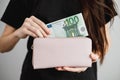 Young woman takes out money euro banknotes from a leather wallet. Close up Royalty Free Stock Photo