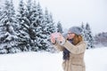 Young woman takes photo on a background of snow-covered winter forest. Royalty Free Stock Photo