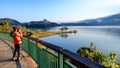 A young woman takes a photo of a beautiful natural scenery at Sun Moon Lake, Taiwan