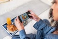 A young woman takes photo of her breakfast platter in bed with cellphone camera Royalty Free Stock Photo