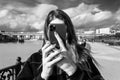 a young woman takes a photo or video on a smartphone covering her face with a smartphone Royalty Free Stock Photo
