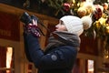 Young woman takes pictures on camera at New Year market