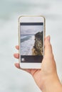 Young woman takes pictures on her phone. Girl taking pictures of a landscape. Royalty Free Stock Photo