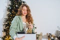 Young woman takes toys for the Christmas tree out of the box Royalty Free Stock Photo