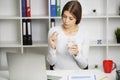 Young woman takes white round pill with glass of water in hand Royalty Free Stock Photo