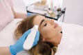 Young woman taking beauty procedure in spa salon. Beautician using peeling device, ultrasonic clining. Gorgeous woman Royalty Free Stock Photo