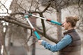 Young woman taking care of garden. Cutting tree branch. Royalty Free Stock Photo