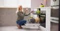 Young woman taking drinking glass from dishwasher Royalty Free Stock Photo