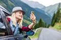 Young woman taking her smartphone in the alps. Royalty Free Stock Photo