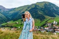 Young woman taking her smartphone in the alps. Royalty Free Stock Photo