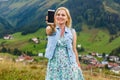 Young woman taking her smartphone in the alps. Royalty Free Stock Photo