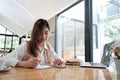 Young woman taking note and looking her mobile phone. Royalty Free Stock Photo