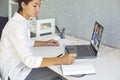 Young woman taking notes during online consultation with coach or video lesson with teacher Royalty Free Stock Photo