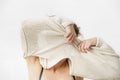 Young woman is taking off her sweater, covering her face. Royalty Free Stock Photo