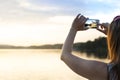 Young woman taking photo of a beautiful sunset with smart phone. Royalty Free Stock Photo