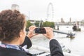 Young woman taking photo of Big Ben in London with her smart phone Royalty Free Stock Photo