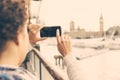 Young woman taking photo of Big Ben in London with her smart phone Royalty Free Stock Photo