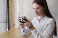 Young woman taking photo at cafe, space for text. Creative hobby Royalty Free Stock Photo