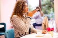 Young woman taking photo of cup of coffee on her smartphone for social networks Royalty Free Stock Photo