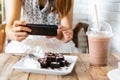 Young woman taking photo of food with smart phone in restaurant Royalty Free Stock Photo