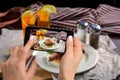 A young woman taking photo of food on smartphone, photographing meal with mobile camera Royalty Free Stock Photo