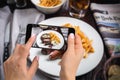 A young woman taking photo of food on smartphone, photographing meal with mobile camera Royalty Free Stock Photo