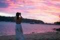 Young woman taking photos with her smartphone on beach during sunset or sunrise Royalty Free Stock Photo