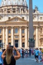 Young woman is taking photos with mobile phone in St. PeterÃÂ´s square in Vatican.