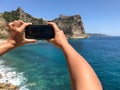 Young woman taking a picture on the beach with a mobile phone Royalty Free Stock Photo